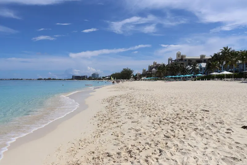 Seven Mile Beach looking north toward the resort skyline, the shoreline a yacht anchored offshore tenders its guests into.
