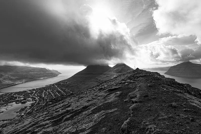 Cloud sits low over a Faroese fjord, the weather that closes in with almost no warning between the 18 islands and is the real limit on a cruising plan here.