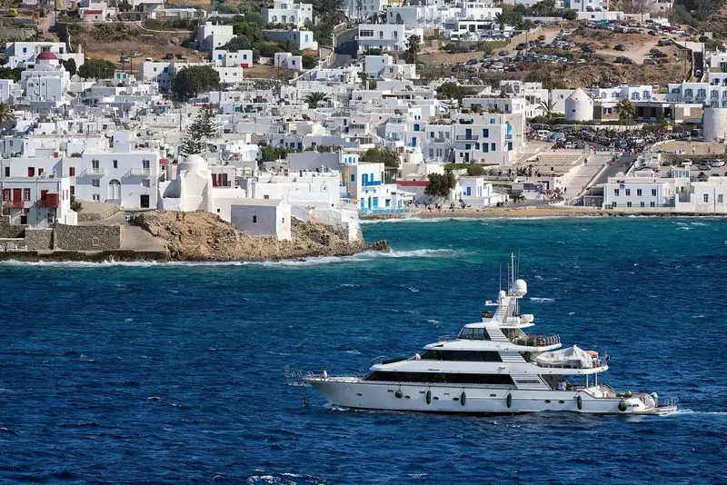 A motor yacht lying off Mykonos town, where the harbour itself takes nothing large.