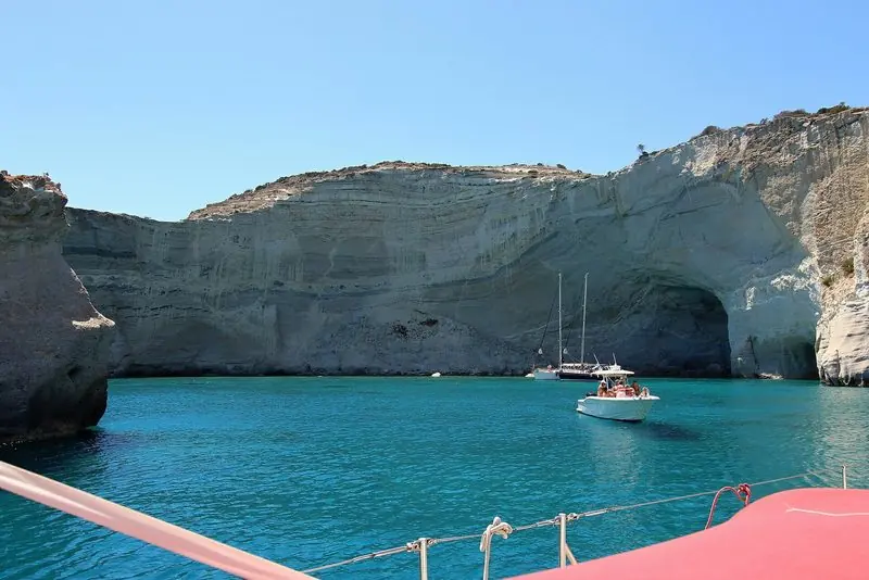 Boats inside the Kleftiko caves, the anchorage that defines a Milos day.