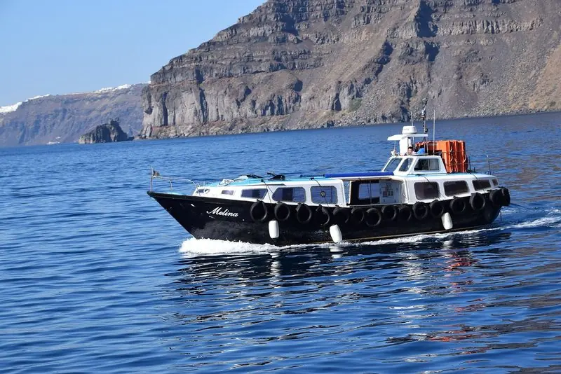 A day boat under the caldera wall at Santorini, where the water is too deep to anchor.