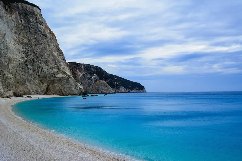Porto Katsiki on the exposed west coast of Lefkada, a pale shelf of water under a white cliff that is a day anchorage in settled weather only.