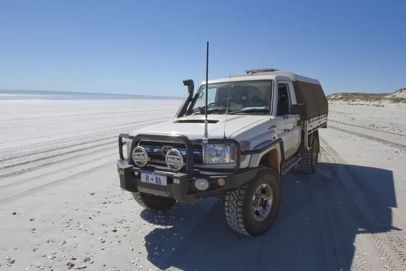A four-wheel-drive on the hard sand of Cable Beach near Broome, the principal gateway town for a Kimberley expedition.