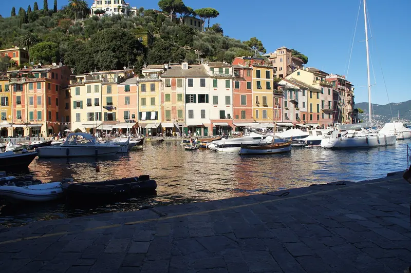 The ochre houses of Portofino stand directly over the quay, which is the entire point of a berth that holds six or seven superyachts.