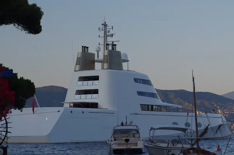 A large motor yacht lies at anchor off Portofino, where boats the sixteen place harbour cannot take wait outside in Cannone Bay or beyond it.