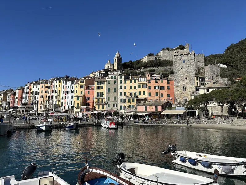 Portovenere at the eastern end of the coast, with the Doria castle above the painted houses and the church out on the point.