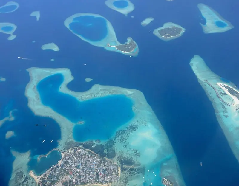 Whole islands sit alone on their reefs here, this one ringed by a fleet of tenders and dive boats with deep water close alongside the beach.