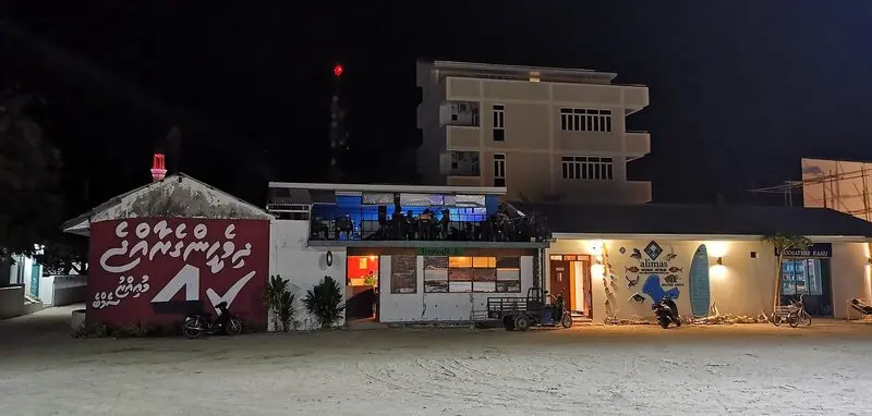 After dark a cafe and dive shop face straight onto the sand of the village street, which is most of what going ashore means on a local island.