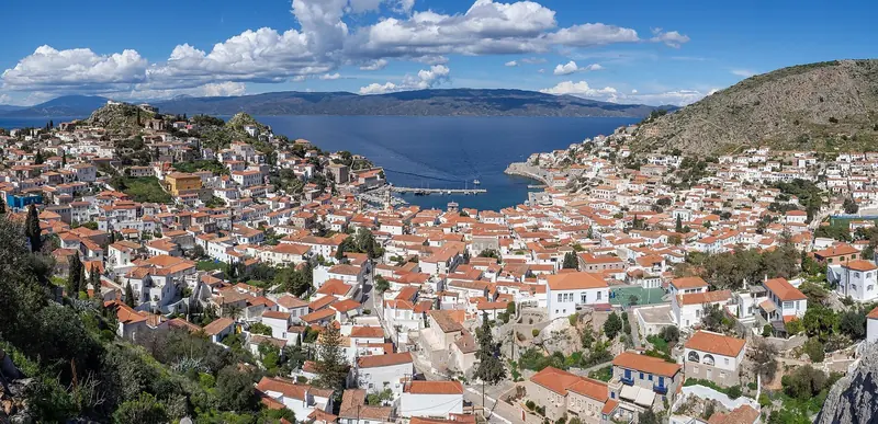 The whole of Hydra Town spreads across its hillside above the water, red-tiled roofs and white walls stepping down in tiers to the harbour.