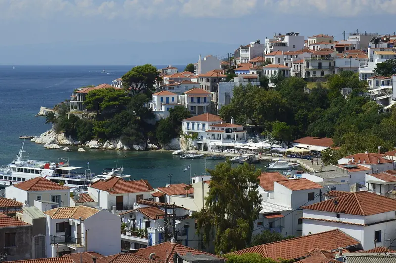 Skiathos town's harbour, whitewashed houses climbing the hill above the boats.