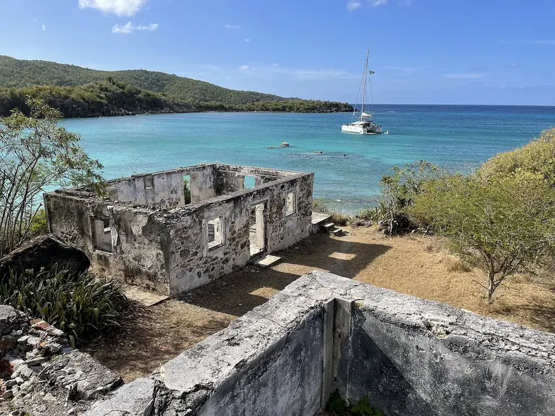 A cruising catamaran anchored off the ruined Lameshur estate house on St John, inside Virgin Islands National Park, which covers about 60 percent of the island