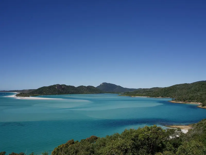 A wide bay between wooded hills, the kind of anchorage that works in the prevailing south easterly and is untenable in a northerly.