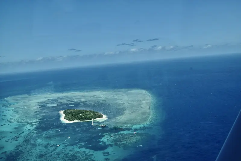 A small coral cay ringed by its own reef, out where the water is clear and the day boats from the mainland turn back.
