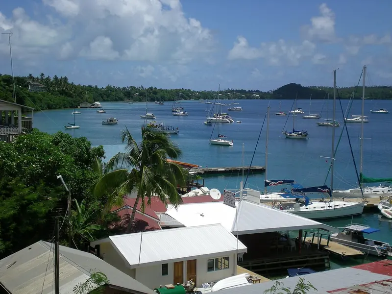 Yachts and catamarans lie at anchor and on moorings in Neiafu's Port of Refuge, the deep, hurricane-shaped harbour that gives Vava'u its name among cruisers.