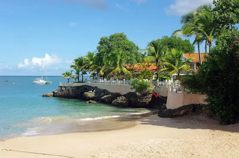 A cruising catamaran anchored off a rocky cove near Store Bay, Tobago, the calmer, more scenic anchorage crews head for once a boat is out of Trinidad's hurricane-season yards.