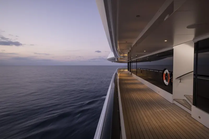 A branded lifebuoy on Amadea's side deck at dusk. Three years in US government custody in San Diego are documented only by reported upkeep spending of roughly 32 to 36 million dollars, not by any disclosed service record.