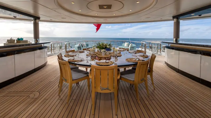 The main deck aft dining table seats up to ten under a covered awning, one of Whisper's several outdoor entertaining areas across five decks.