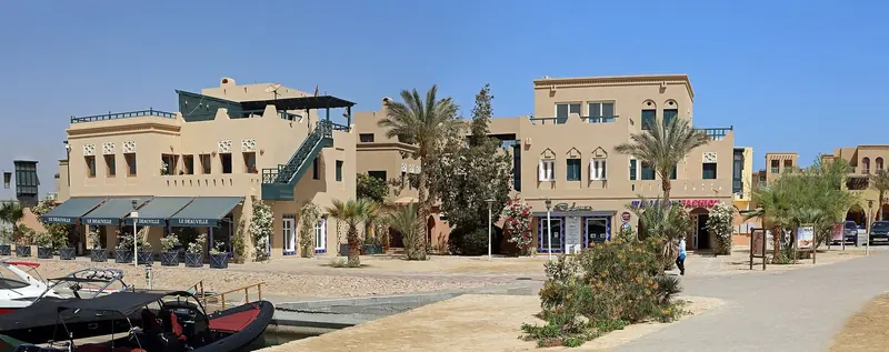 The South Basin quay, ribs and tenders on the pontoon in front of the Le Deauville restaurant row and its Venetian-Nubian arches.