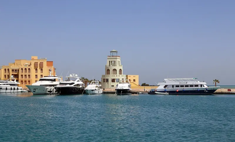 The North Basin's domed watchtower between berthed motor yachts and the liveaboard Rosetta III, one of the dive boats that work out of the marina.