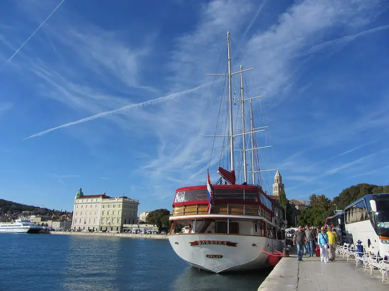 A motor sailer alongside on Split harbour, the town quay immediately behind. The marina lies across the water on the far side of the basin.