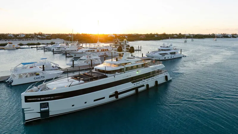 A motor yacht arriving past the marina at sunset, Providenciales in the background