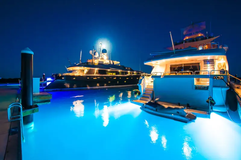 Megayachts alongside the floating docks at Blue Haven Marina after dark