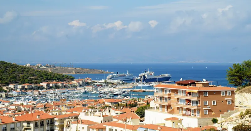 An elevated view over Cesme's harbor basin and the red-roofed town that wraps around it.