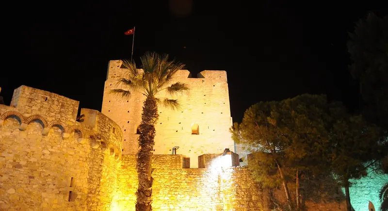Cesme Kalesi floodlit after dark, the fortress that stands directly above the marina and is the town's landmark after the boats come in.