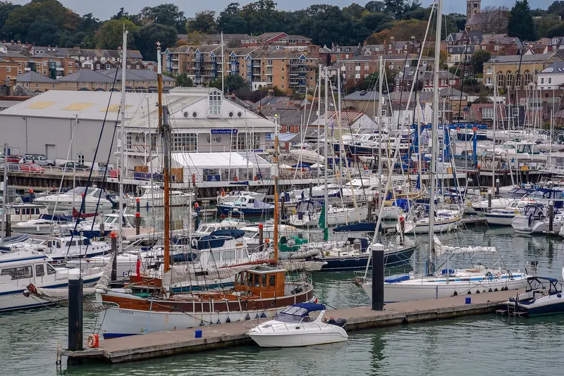 Cowes Yacht Haven's pontoons on the River Medina, with the marina office and the town's waterside terraces behind.