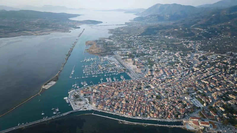 Lefkada town and the marina basin from the air, the causeway that carries the road onto the island visible behind it.
