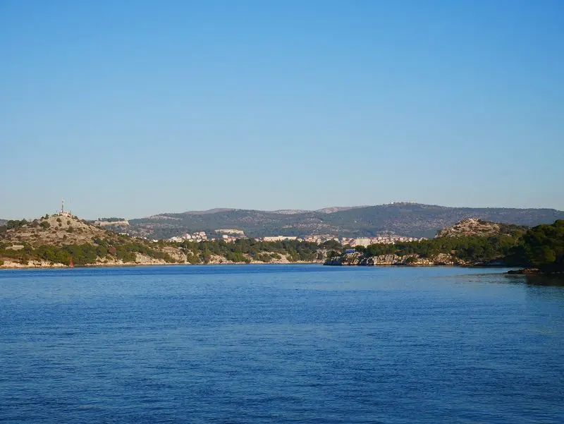 Boats reach Sibenik through the St Anthony Channel, a narrow cut between low limestone headlands that keeps any sea out of the marina.