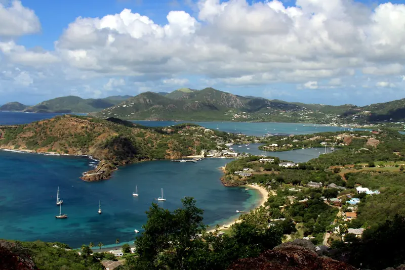 English Harbour from the hills above it. Falmouth Harbour lies over the ridge to the west, and the two work as one base with the superyacht berths split between them.