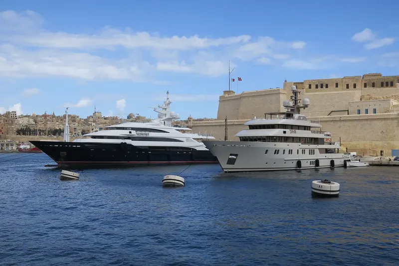 The superyachts Amevi and Polar Star lie off Senglea in the Grand Harbour, the bastions of the Three Cities directly behind them.
