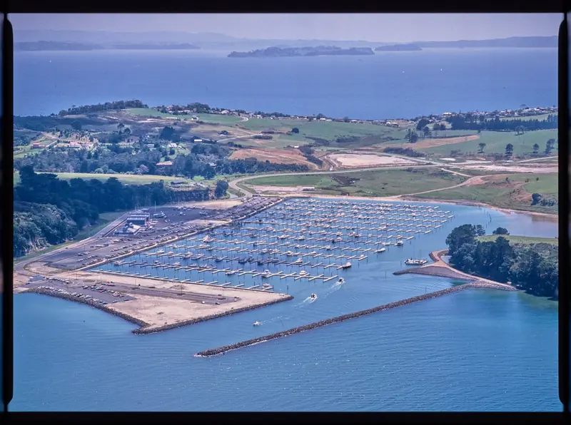 Gulf Harbour Marina newly built in the 1980s, the breakwater and pontoons still surrounded by open farmland.