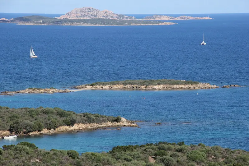 The islet of Portisco just offshore, with the small-boat and charter traffic that works this stretch of the Costa Smeralda coast.