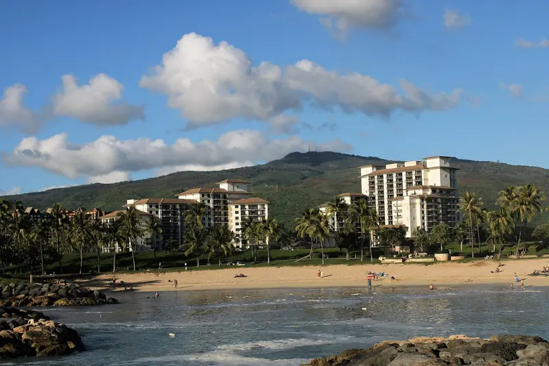 The resort towers seen from the rocks at the edge of one of Ko Olina's four lagoons, the shoreline walk that links the marina to the beaches.