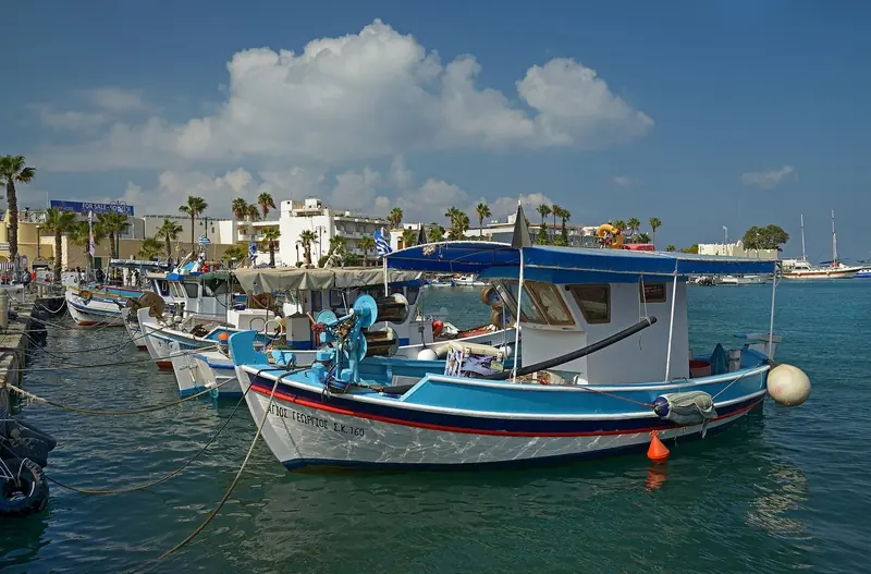 Traditional Kos fishing caiques moored in the old harbour, the everyday working boats that share this stretch of coast with the marina.