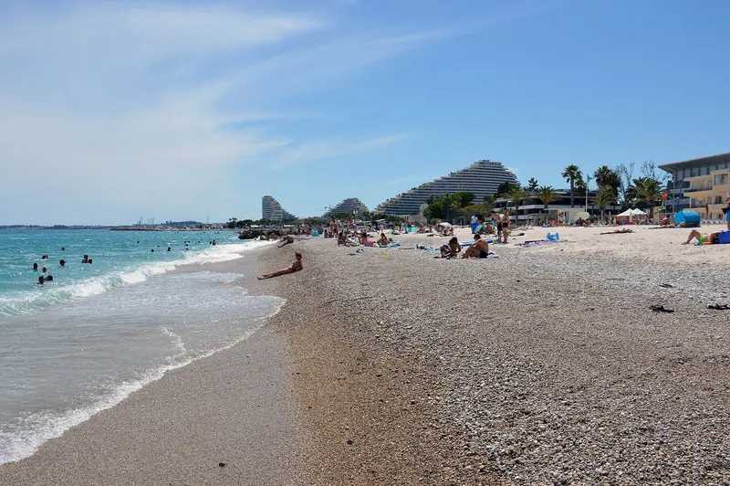Looking along Plage des Bouches du Loup toward Marina Baie des Anges, the pyramids marking the marina from along the coast.