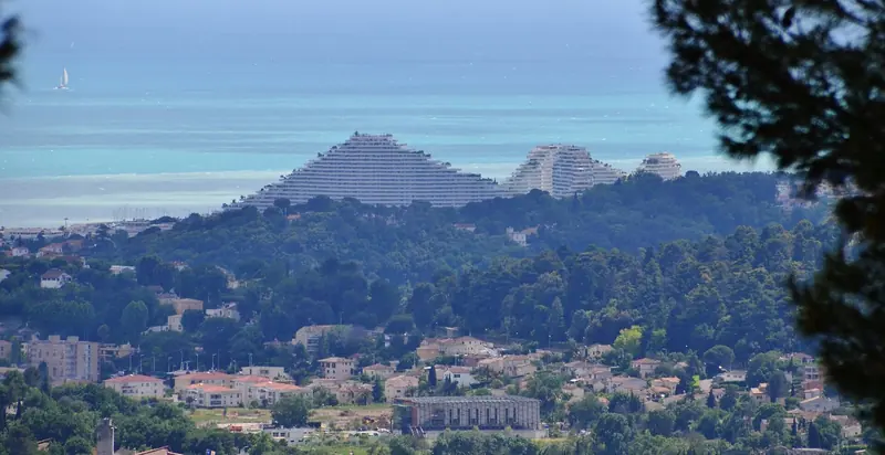 Villeneuve-Loubet and the Baie des Anges towers seen from the hills above, the marina basin at their foot.