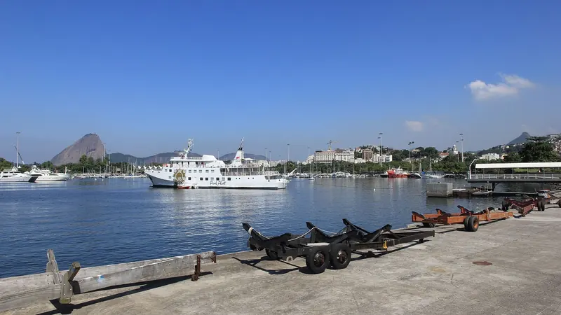 The excursion boat Pink Fleet (Spirit of Brazil VII) moored off the marina with Sugarloaf behind it, dry-stack boat cradles lined up on the quay in the foreground.