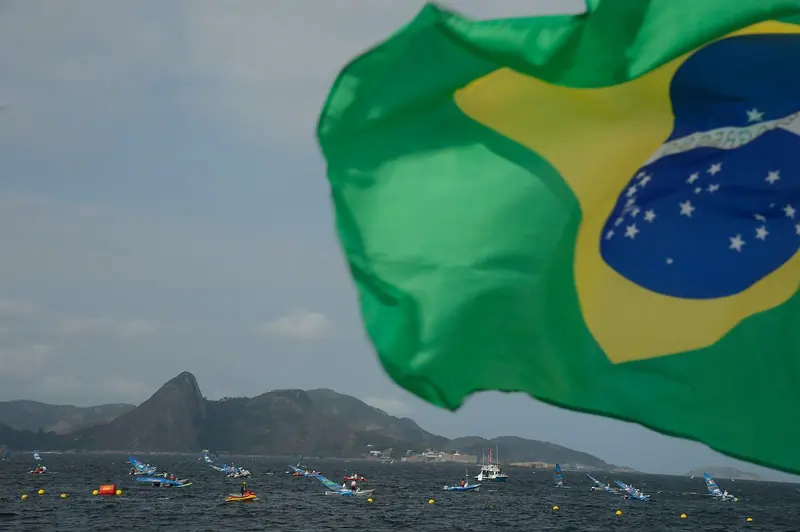 Dinghies and windsurfers racing on Guanabara Bay during the 2016 Olympics, the water Marina da Gloria's sailors launched into, with Sugarloaf and the bay's fortified islands behind.