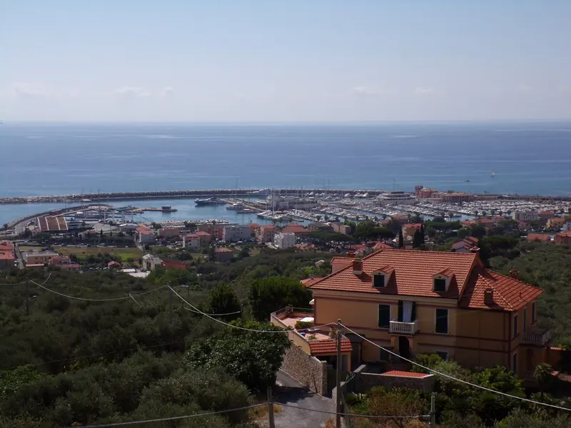The port seen from the Santi Cosma e Damiano sanctuary on the hill above town, the breakwater and pontoons laid out below.