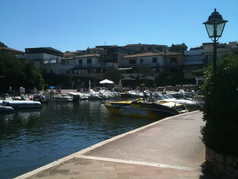 From the hillside the harbour reads as one dense basin of motor yachts, the biggest boats along the outer quay and the village stacked above the water.