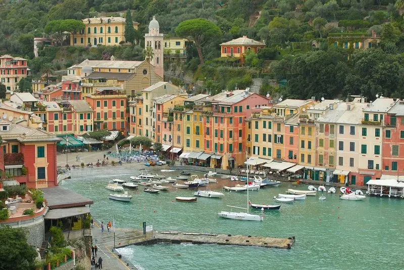 From above, the scale of the place is plain: one short arc of quay, the parish church and its campanile on the slope, and every boat on a mooring in the middle of the water.