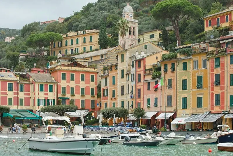 Restaurants and shops fill the ground floors of the harbour-front houses, the campanile standing above them on the hillside.