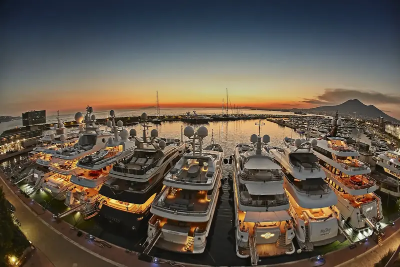 Superyachts nose-in along the quay at dusk, the ISPS-designated berthing that runs the length of the 3-kilometre waterfront