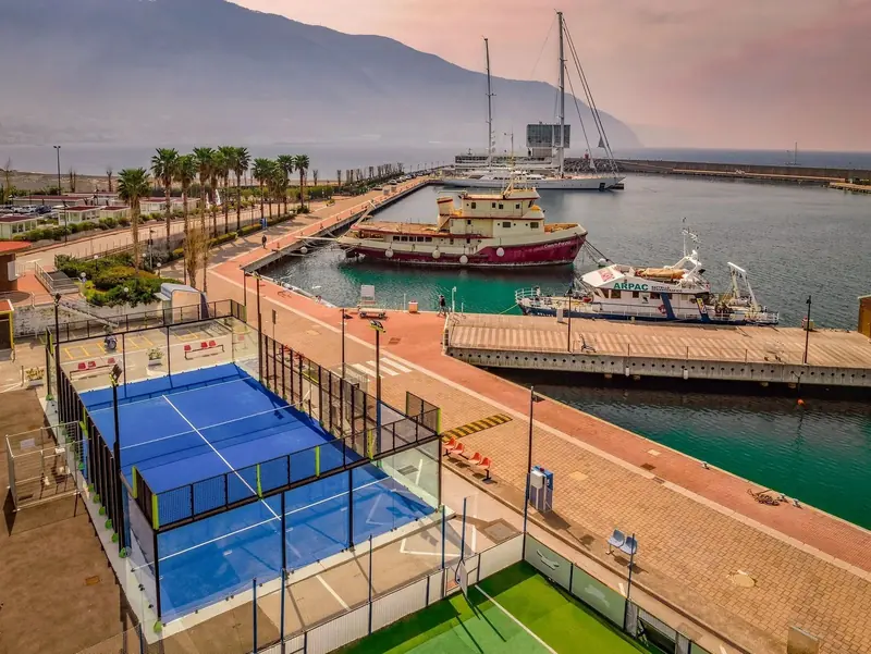 The marina promenade running past a padel court to the technical basin, part of the 2,980 metres of waterfront walkway