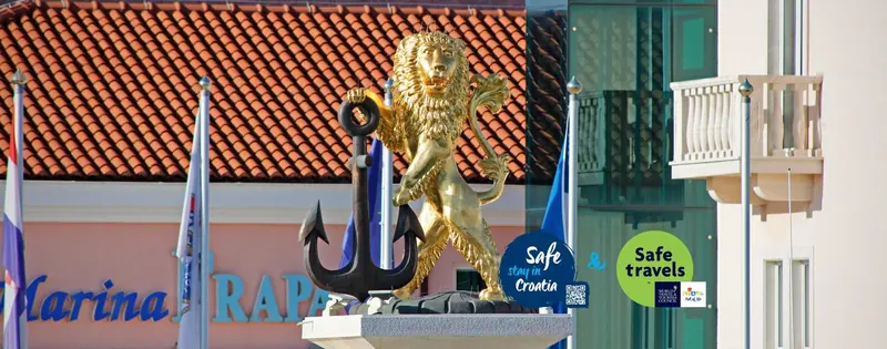 The gilded lion and anchor at the marina entrance, a Rogoznica landmark since the resort's early years.