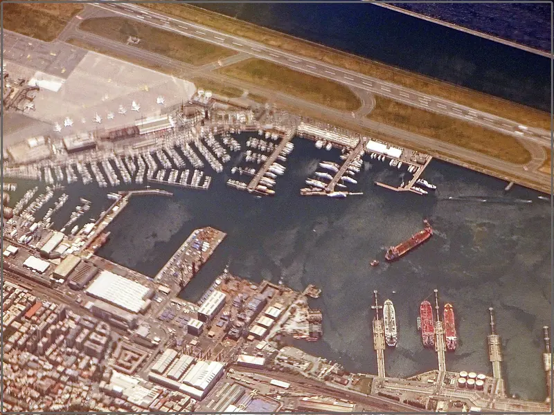 Sestri Ponente from the air: the marina basins lie hard against the Fincantieri yard and the runway of Genoa airport, which is what puts the terminal ten minutes from the passerelle.