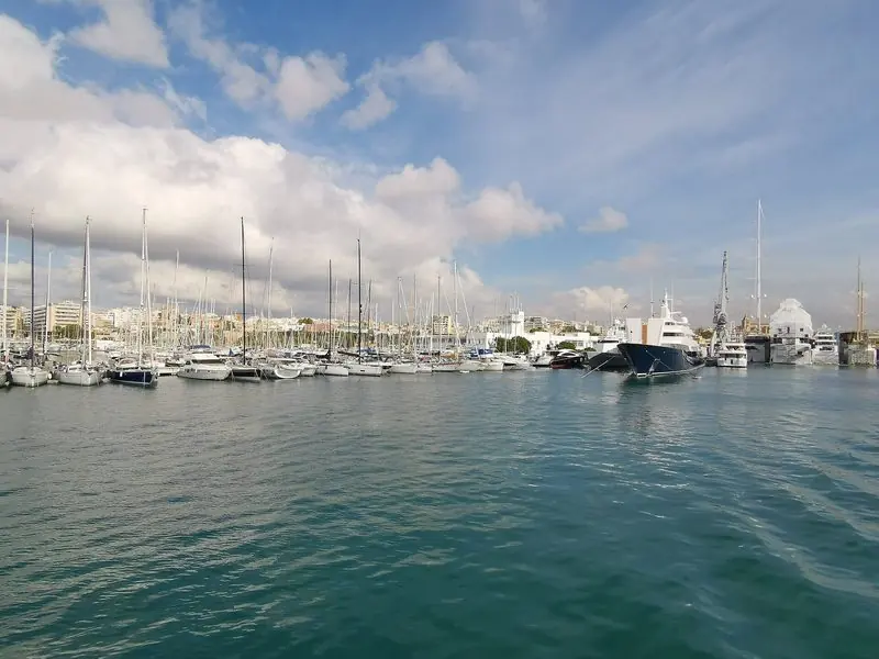 Seen from the water, the basin runs from cruising sailing boats on the near pontoons out to a navy hulled superyacht lying against the yard sheds on the far side.